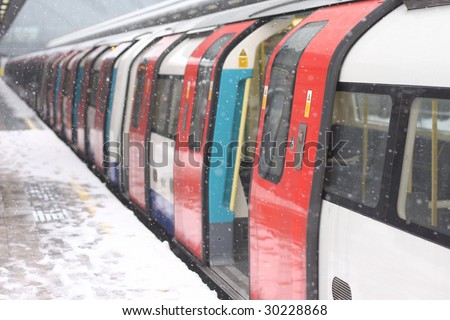 London underground train in the snow waiting for people to board