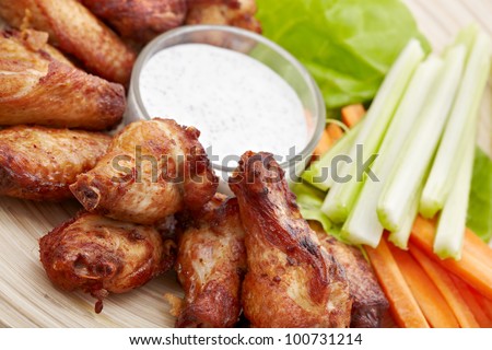 Fried chicken legs and wings with fresh vegetables and hot mayonnaise sauce. Snack to beer. Closeup.