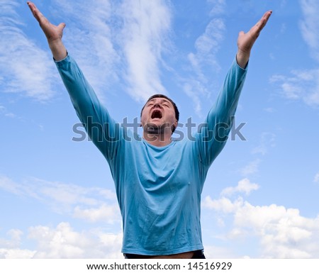 Man against a sky on background rise his hands up and cry