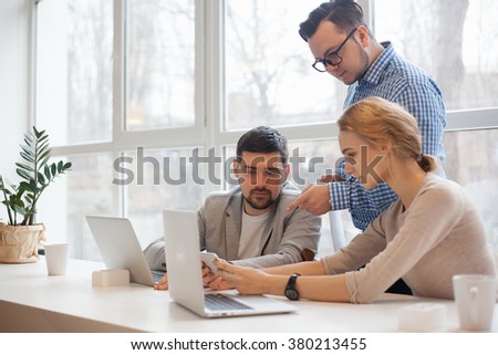 team of three coworkers in stylish studio