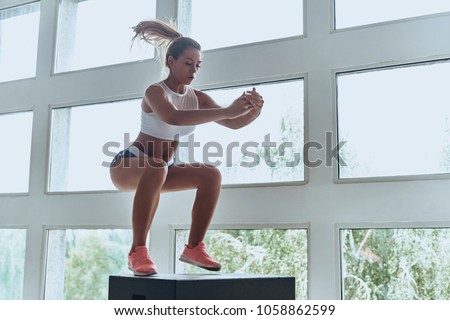 Always in good shape. Modern young woman in sport clothing jumping while exercising in the gym