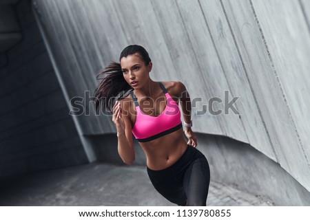 Best cardio ever. Modern young woman in sports clothing running while exercising outdoors
