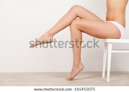 Beautiful Legs. Close-Up Of Woman In White Panties Sitting On The Chair