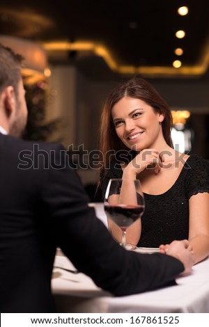 Romantic Date At The Restaurant. Beautiful Young Couple Talking To Each Other And Smiling While Spending Time At The Restaurant