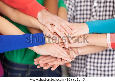 We are strong when we together. Close-up of many hands clasped together