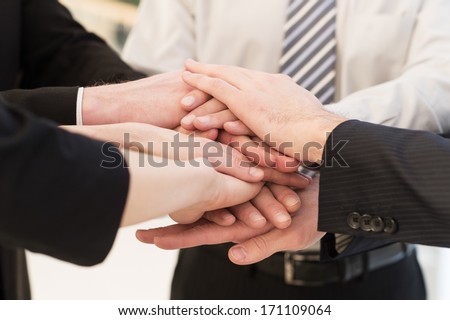 We are team. Close-up of many business people?s hands clasped together
