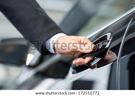 Opening his new car. Close-up of male hand holding the car handle