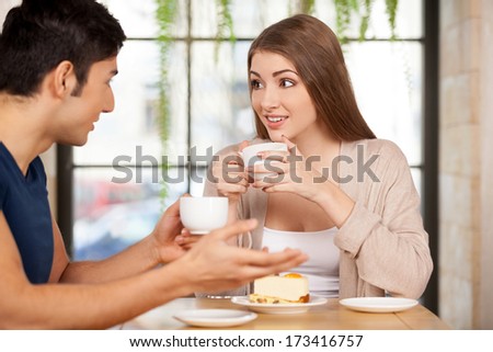 Couple at the restaurant. Beautiful young couple sitting together at the restaurant and drinking coffee