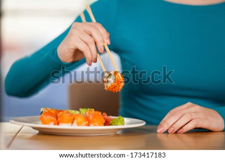 Eating sushi. Close-up of woman eating sushi at the restaurant