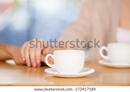 Couple holding hands. Close-up of couple holding hands while sitting together at the restaurant