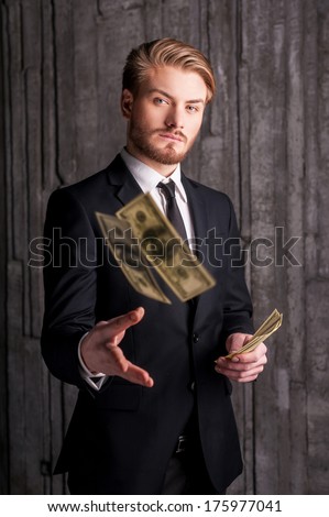 Rich And Successful. Handsome Young Man In Formalwear Throwing Money And Looking At Camera