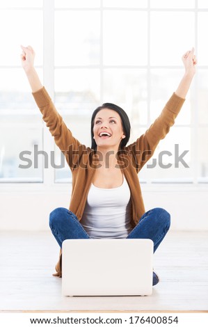 Successful young woman. Female student with a laptop cheering in success