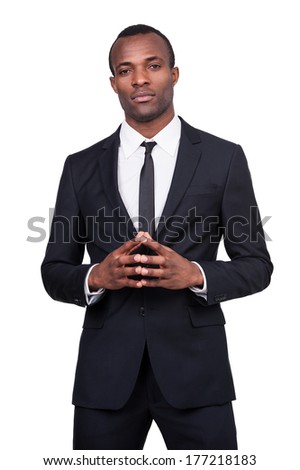 Power and success. Thoughtful young African man in formalwear holding hands clasped while standing isolated on white background