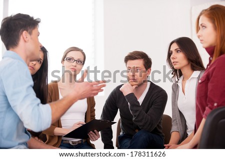 I want to share my problem. Group of people sitting close to each other while man telling something and gesturing