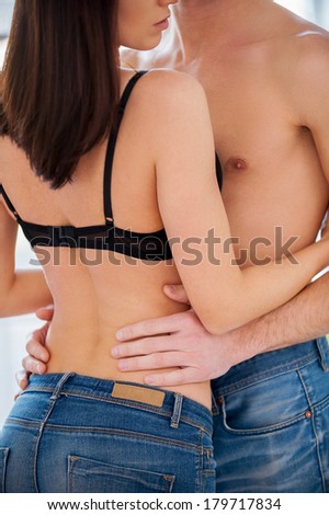 Loving couple hugging. Cropped image of beautiful young shirtless couple hugging