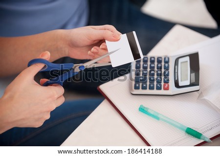 Cutting the expenses. Cropped image of woman cutting a credit card with scissors