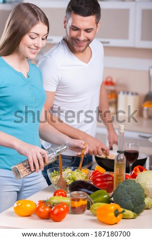 Couple cooking dinner. Happy young couple cooking dinner in the kitchen