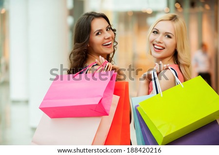 Happy friends shopping. Two beautiful young women enjoying shopping at shopping mall