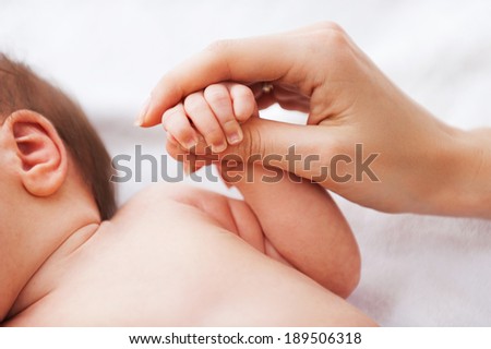 It is so tiny. Close-up of father holding a tiny hand of his little baby