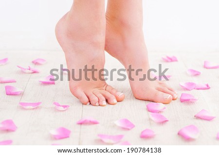 Keeping her feet fresh and clean. Side view cropped image of beautiful female feet on hardwood floor