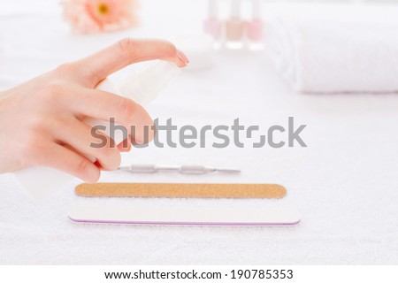Preparing instruments for manicure. Close-up of manicure master spraying antiseptic on instruments for manicure