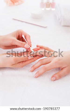 Preparing nails for manicure. Close-up of beautician cleaning nails of female customer