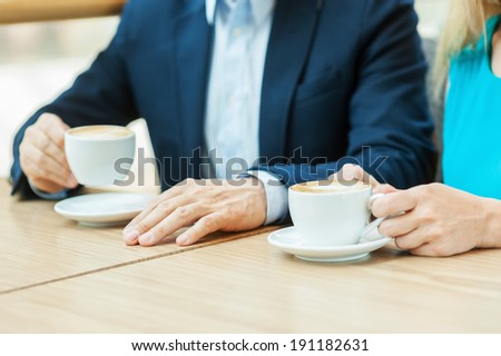 Couple in coffee shop. Top view of couple drinking coffee together while sitting in coffee shop