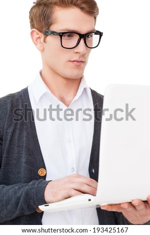 IT guy. Handsome young man working on laptop while standing isolated on white