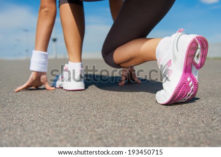 Getting ready to run.  Close-up image of woman in sports shoes standing in starting line