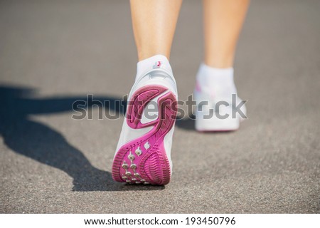 Walking in sports shoes.  Close-up image of woman in sports shoes walking