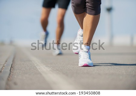 People running.  Close-up image of woman and man running along the running track