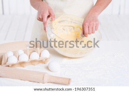 Cooking pastry. Close-up of woman mixing dough in a mixing bowl