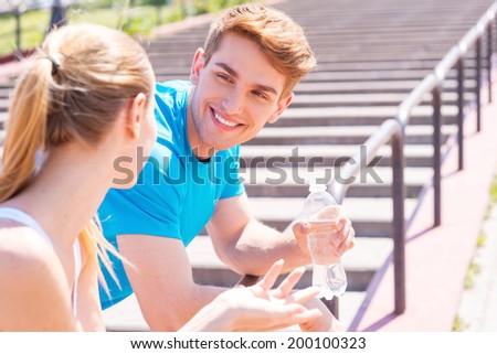 Fitness couple. Young couple in sports clothing standing face to face and smiling