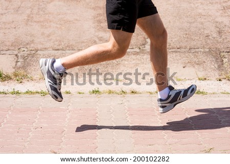 On the run.  Side view close-up image of man running outdoors