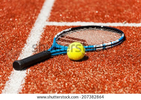 Play tennis? Close-up of tennis racket and tennis ball laying on the court