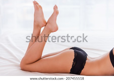 She got perfect buttocks. Close-up of woman with perfect buttocks lying on the bed