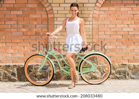 Beauty with vintage bike. Full length of attractive young smiling woman standing near her vintage bicycle