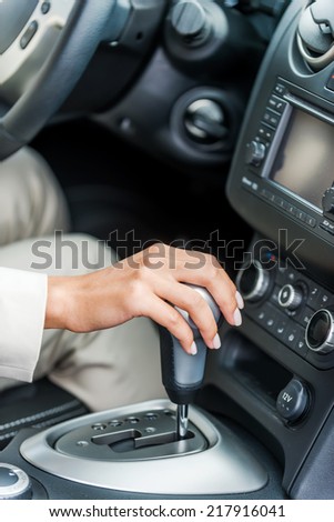 Driving a car. Close-up of woman in formalwear driving car
