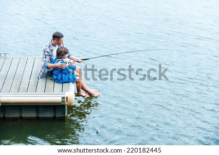 Father and son fishing. Top view of father and son fishing together on quayside