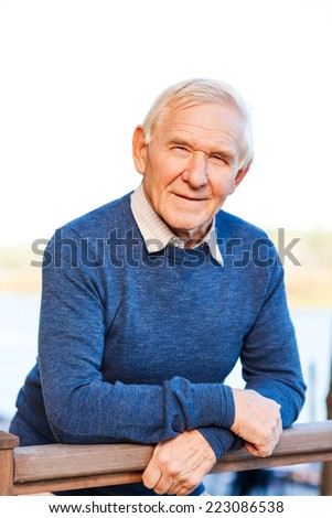 Confident senior man. Confident senior man looking at camera and smiling while standing outdoors