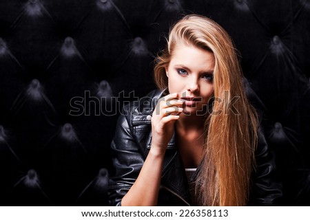 Seducing you. Beautiful young woman with make up and posing against black background