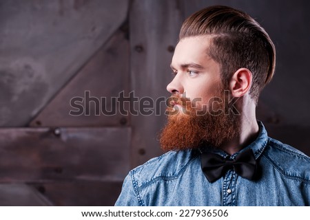Perfect hairstyle. Profile portrait of handsome young bearded man looking away