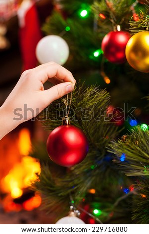 Decorating Christmas Tree. Close-up of child decorating Christmas Tree with Christmas Balls