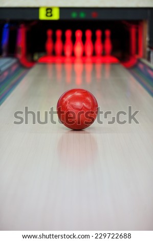 Moment when the heart stops beating. Close-up of bright red bowling ball rolling along bowling alley