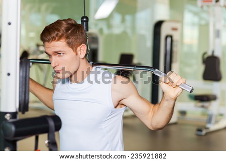 Strong and motivated. Handsome young muscular man working out on bench press