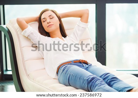 Total relaxation. Beautiful young woman holding hands behind head while sleeping on the couch