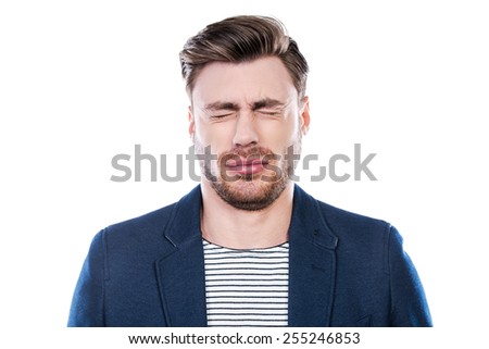 Oh no! Portrait of young man expressing negativity and keeping eyes closed while standing against white background
