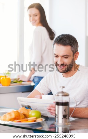 Spending good morning together. Beautiful young couple spending time in the kitchen together