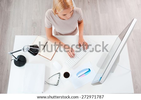 Business first. Top view of beautiful young blond hair woman working at the computer while sitting at her working place