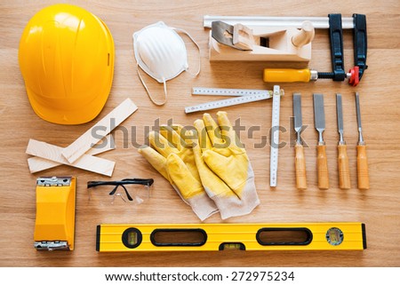 Work tools for carpenter. Top view of diverse working tools for wood industry laying on the wood grain